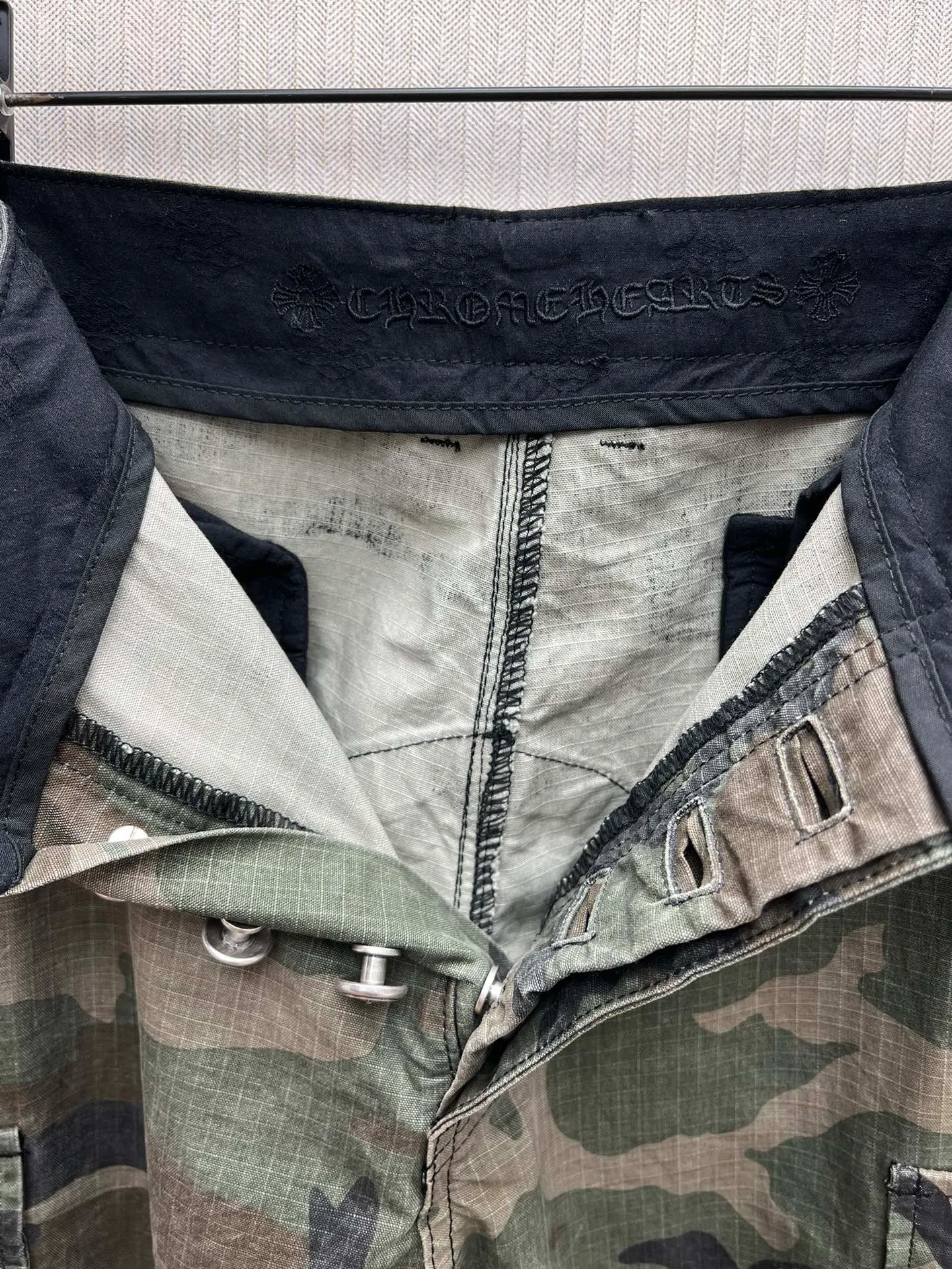 🅿️680 Crow Heart 25SS camouflage patchwork leather genuine antique silver overalls. The body fabric is custom-dyed with fully divided camouflage. The lining is CH jacquard lining. The minimum order is 1000 meters. There are 14 genuine antique silver hardware in the whole trousers. Half of the cost is in the hardware. The leather patchwork is made of imported lambskin. Hand-made edge turning method. The embroidery on the waist is imported Tajima machine. Precision embroidery. Size: 32.34.36